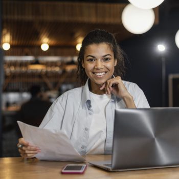 front-view-smiley-woman-working-office-front-laptop
